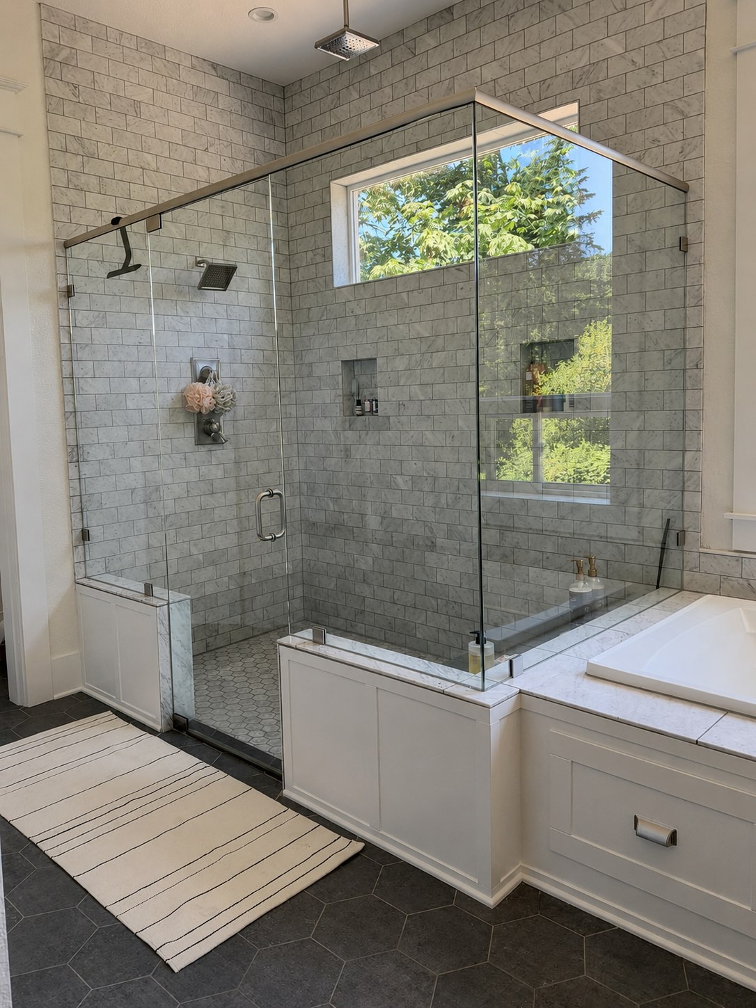 A marble-tiled walk-in shower and freestanding tub, cleaned and cared for by Cascadia Home Wellness